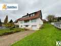 Foto Idyllisches Wohnen in Hanglage: Einfamilienhaus mit Garage und sonniger Terrasse